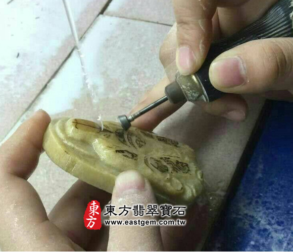 玄天上帝翡翠吊墜製作過程-用鑽頭將服裝的輪廓大致雕出