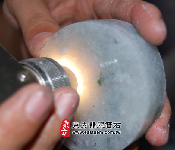這是另一個冰種飄蘭花手鐲，所取出來的手鐲心。用LED手電筒去照，就會看出這個翡翠的料子很透光，水頭好，可以使用來做觀音吊墜。